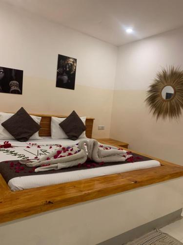a bedroom with a wooden bed with flowers on it at Varadero Zanzibar Hotel 2 in Kendwa