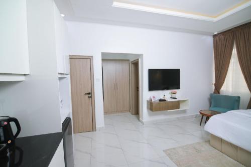 a hotel room with a bed and a television at Fort Fountain Apartments in Abuja