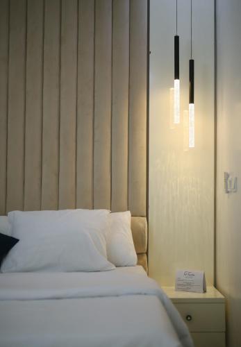 a bed with white sheets and a headboard in a room at Fort Fountain Apartments in Abuja
