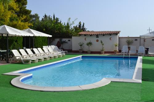a swimming pool with lounge chairs and a pool at Hotel Miravalle in Misilmeri