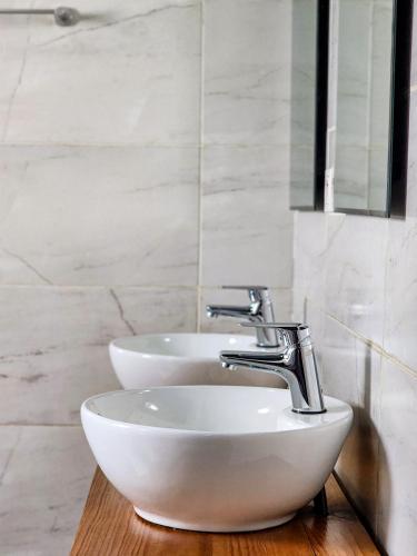 a bathroom with two sinks and a mirror at La Casa Di Luna - Hotel with Pool and Restaurant in Antananarivo in Antananarivo