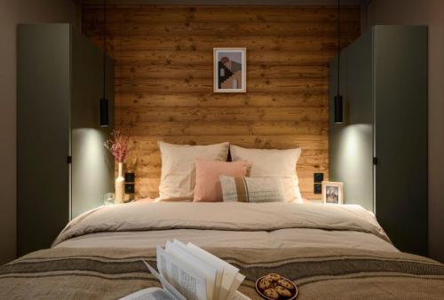 a bedroom with a large bed with a wooden wall at Résidence Camping La Buidonniere - Chalet confortable et lumineux en pleine nature MAE-1053 in Aussois