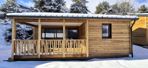 una baita di tronchi con terrazza nella neve di Résidence Camping La Buidonniere - Chalet confortable et lumineux en pleine nature MAE-1033 ad Aussois