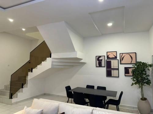 a living room with a staircase and a table and chairs at Crystal's apartment in a secure estate with pool in Ibeju