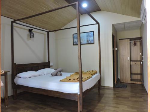 a bedroom with a canopy bed with white sheets at Abba's Glory Land - Agonda in Agonda