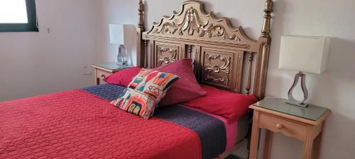 a bedroom with a red bed with red pillows at Anaga Tucho Natural Beach House in Santa Cruz de Tenerife