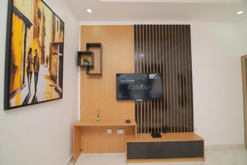 a living room with a tv on a wall at Fort Fountain Apartments in Abuja