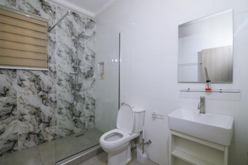 a bathroom with a white toilet and a sink at Fort Fountain Apartments in Abuja