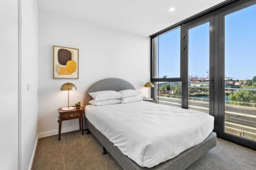 a bedroom with a bed and a large window at Modern 1-Bedroom Apartment, Perfect City Getaway in Melbourne