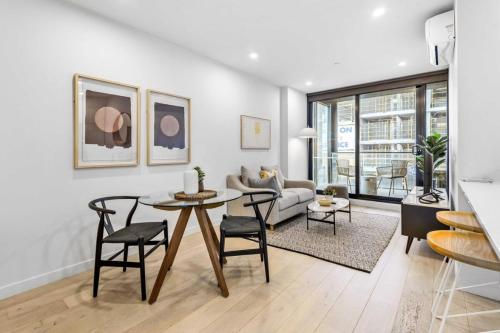a living room with a table and chairs and a couch at Modern 1-Bedroom Apartment, Perfect City Getaway in Melbourne
