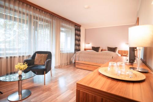a bedroom with a bed and a desk with a chair at Hotel Bavaria - Partnerbetrieb von Oberstaufen PLUS in Oberstaufen