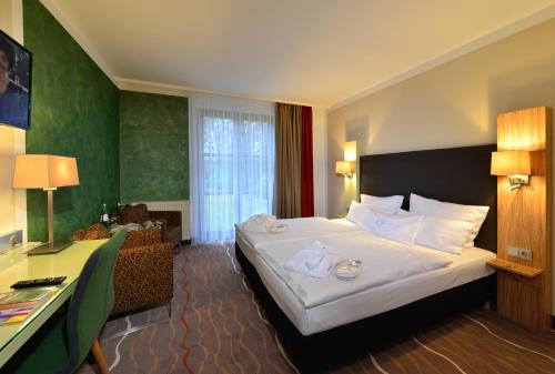 a hotel room with a bed and a desk at Landhotel Schnuck in Schneverdingen