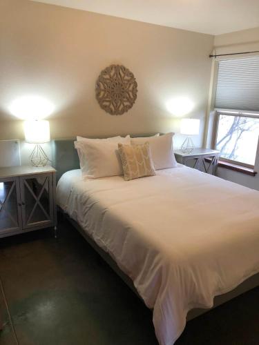 a bedroom with a large white bed with two tables at Trail Street Condo Downstairs in Missoula