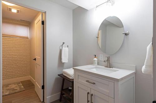 a white bathroom with a sink and a mirror at Salish Court in Missoula