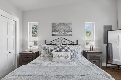a bedroom with a bed and two night stands and two windows at Griz Country Cottage in Missoula