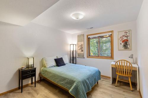 a bedroom with a bed and a table and a chair at Close to downtown on Riverfront Park in Missoula