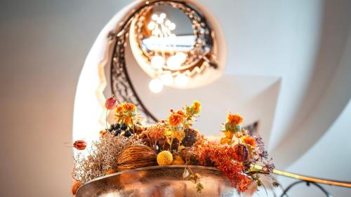 a mirror and a vase with flowers in it at Hotel Bavaria - Partnerbetrieb von Oberstaufen PLUS in Oberstaufen