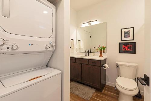 a bathroom with a toilet and a sink with a mirror at The Railway Flats 102 in Missoula