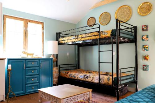 a bedroom with two bunk beds and a table at Domek Wróżki - Sanktuarium Laparica w Puszczy Białej 