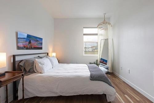 a white bedroom with a large bed and a window at The Railway Flats 101 in Missoula
