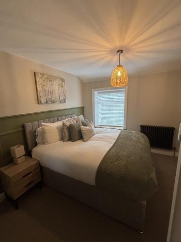 ein Schlafzimmer mit großem Bett und Fenster in der Unterkunft Sunset Cottage - 55 South Lane in Holmfirth