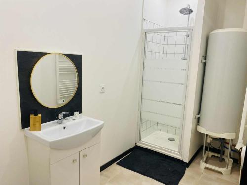 a bathroom with a sink and a shower with a mirror at Charmant T2 centre ville N 4 in Marmande