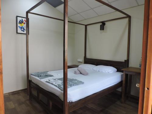 a bedroom with a canopy bed with white sheets at Abba's Glory Land - Agonda in Agonda