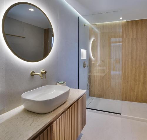 a bathroom with a sink and a shower with a mirror at Divel Luxury Villas with heated pools, by Estia in Anissaras