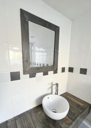 a bathroom with a white sink and a mirror at Rodney Retreat, Ramsgate Kent in Haywards Heath