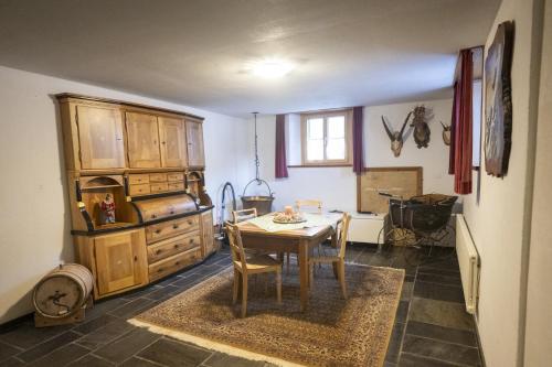 a kitchen with a table and a wooden cabinet at Chasa Bugliet in Sent