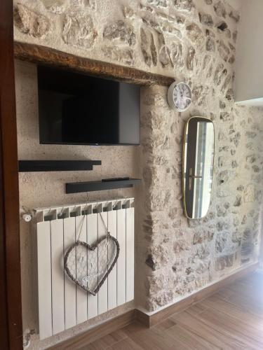 a stone wall with a tv and a heart on it at Victor's House in Pacentro