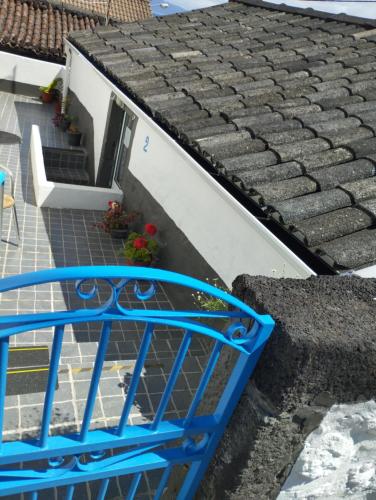 a blue bench on the side of a house at Casa de Lá in São Roque do Pico