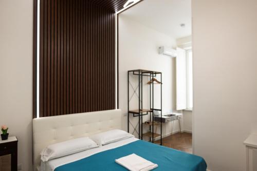 a bedroom with a bed with a blue blanket at Relais Malta Luxotel in Salerno