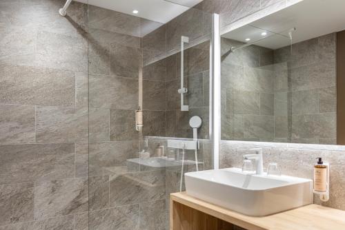 a bathroom with a sink and a mirror at Mercure Ax Les Thermes in Ax-les-Thermes