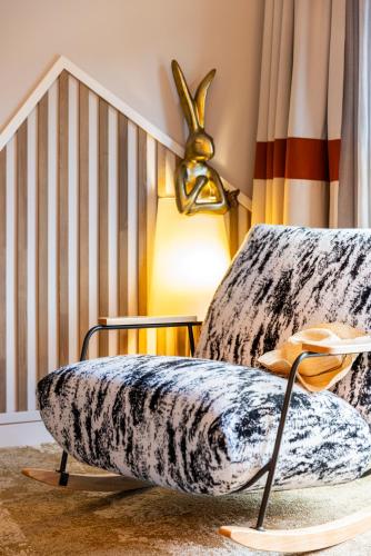 a room with a chair with a large cushion at Mercure Ax Les Thermes in Ax-les-Thermes