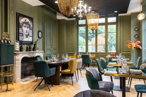 a restaurant with tables and chairs and a fireplace at Mercure Ax Les Thermes in Ax-les-Thermes