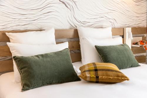 a bed with four green pillows on it at Mercure Ax Les Thermes in Ax-les-Thermes