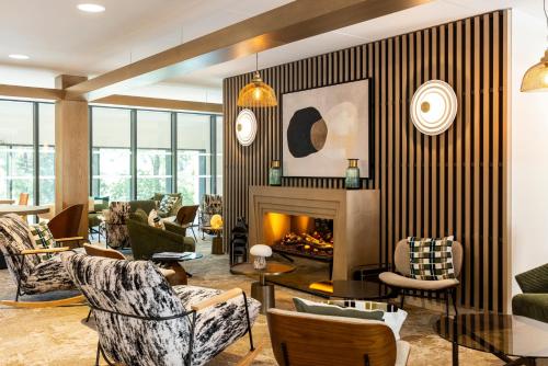a living room with furniture and a fireplace at Mercure Ax Les Thermes in Ax-les-Thermes