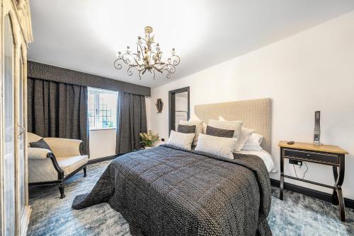 a bedroom with a bed and a chandelier at The Stables in Hambleton