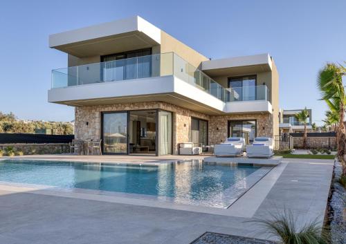 a house with a swimming pool in front of it at Divel Luxury Villas with heated pools, by Estia in Anissaras