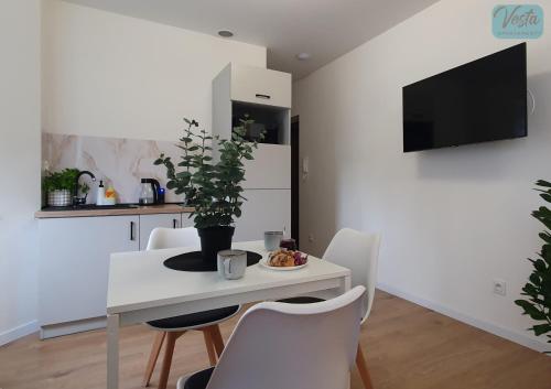 a dining room with a white table and chairs at VESTA Apartamenty M52 Free parking in Szczecin