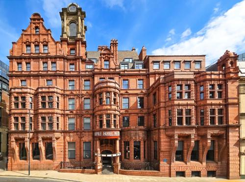 an old red brick building with a clock tower at The Met Hotel Leeds - Newly Refurbished in Leeds