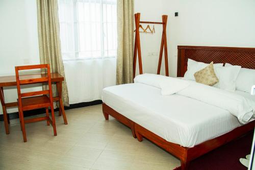 a bedroom with two beds and a desk and a chair at Maasai Villa in Arusha