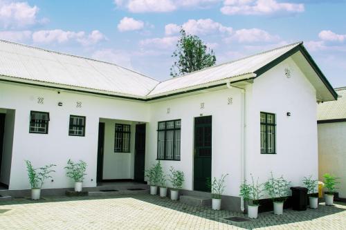 a white house with potted plants in the courtyard at Maasai Villa in Arusha