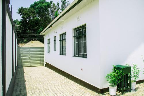 a white building with black windows and a fence at Maasai Villa in Arusha