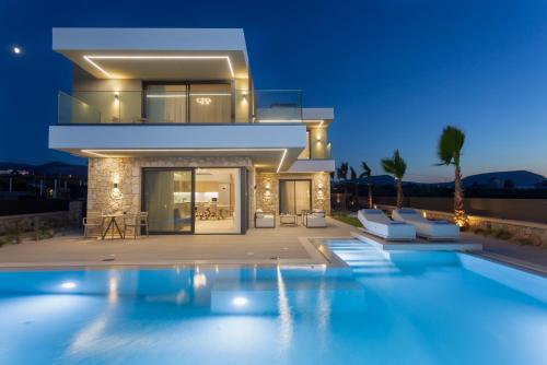 a villa with a swimming pool at night at Divel Luxury Villas with heated pools, by Estia in Anissaras