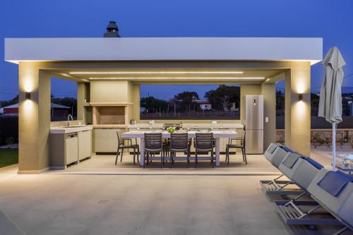 a large outdoor kitchen with a table and chairs at Divel Luxury Villas with heated pools, by Estia in Anissaras