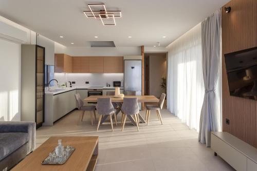 a living room and kitchen with a table and chairs at Divel Luxury Villas with heated pools, by Estia in Anissaras
