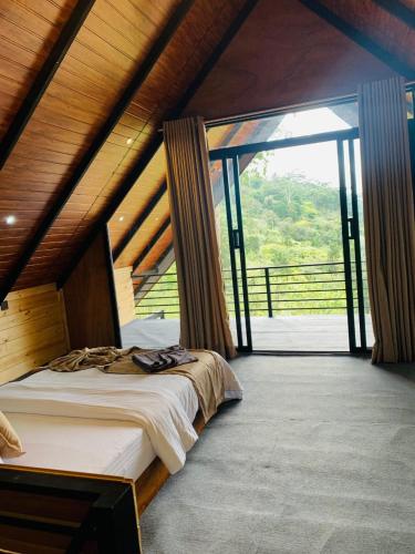 une chambre avec un lit et une grande fenêtre dans l'établissement Sunset Cottage Ella, à Ella