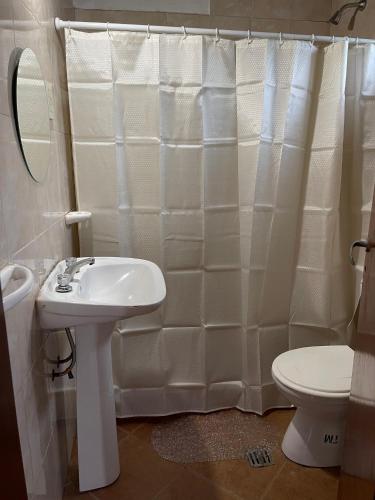 a white bathroom with a sink and a toilet at Complejo Juan Pablo in Colón